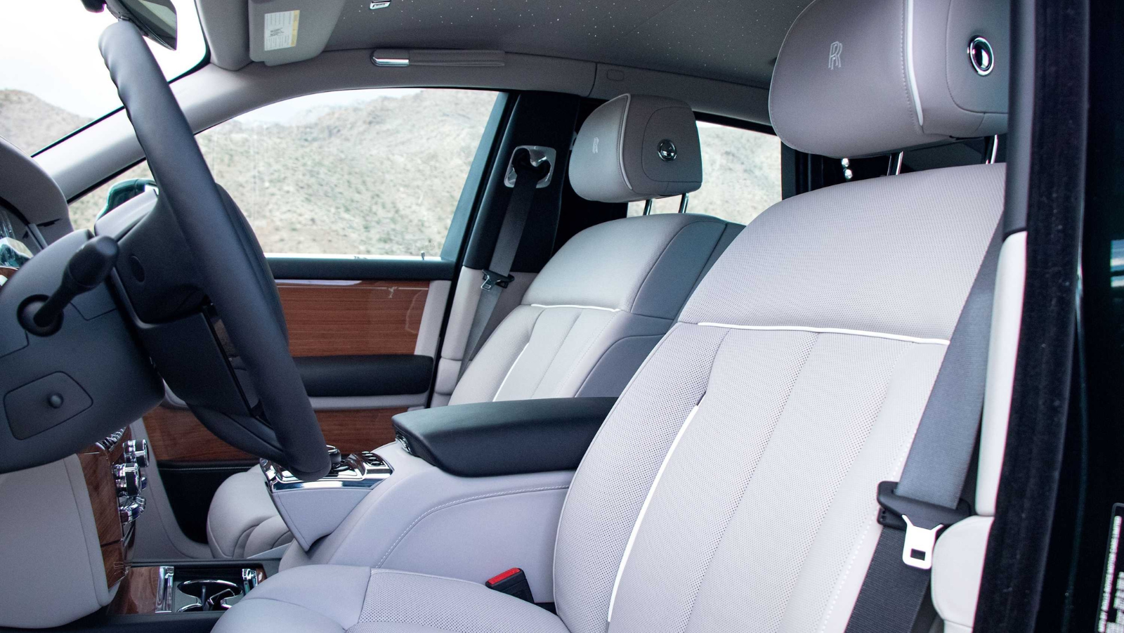 Car interior with white seats and steering wheel, showing dashboard and side view.